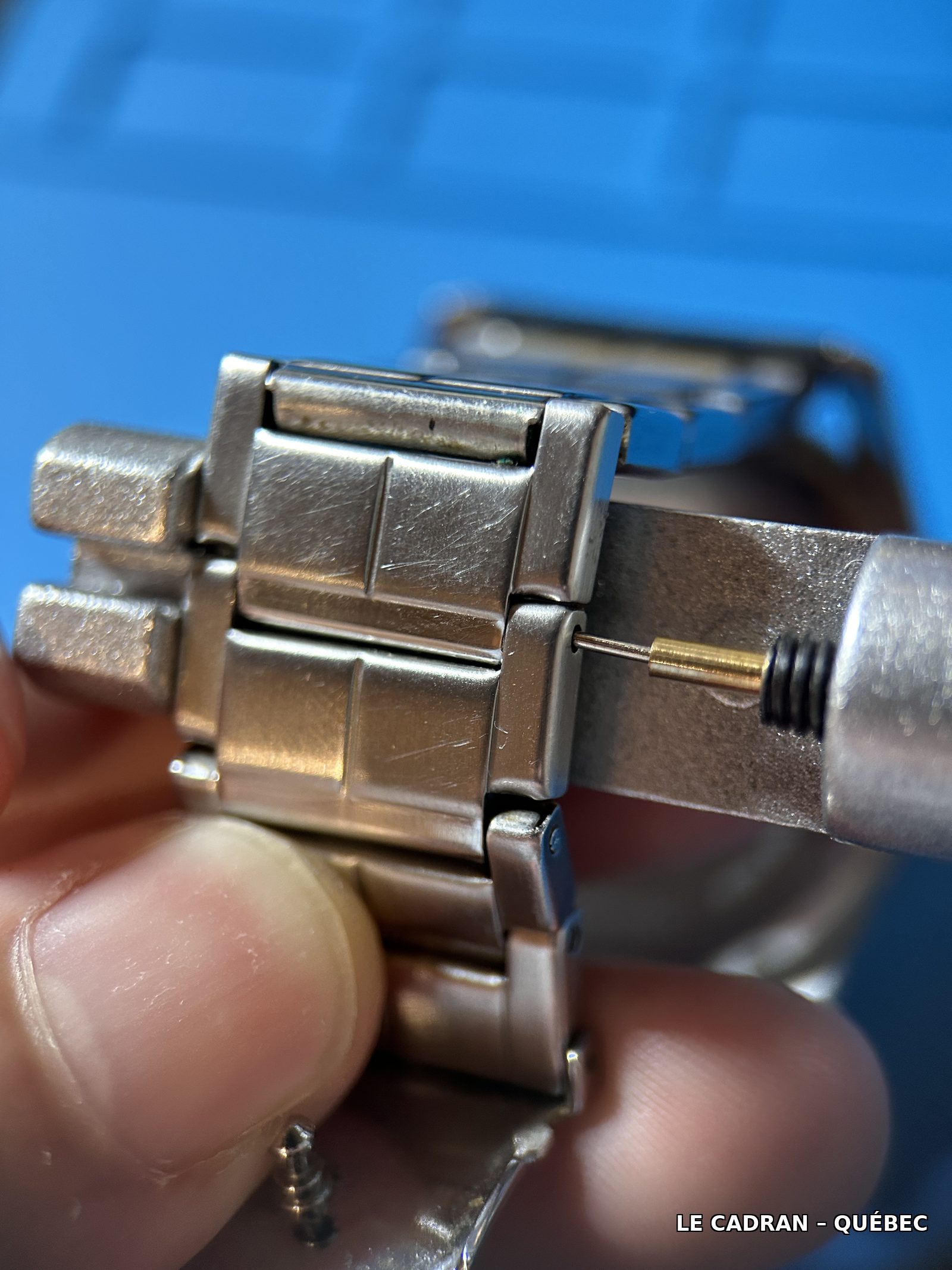 Outil à retirer les maillons en cours d'utilisation, goupille partiellement poussée hors du bracelet