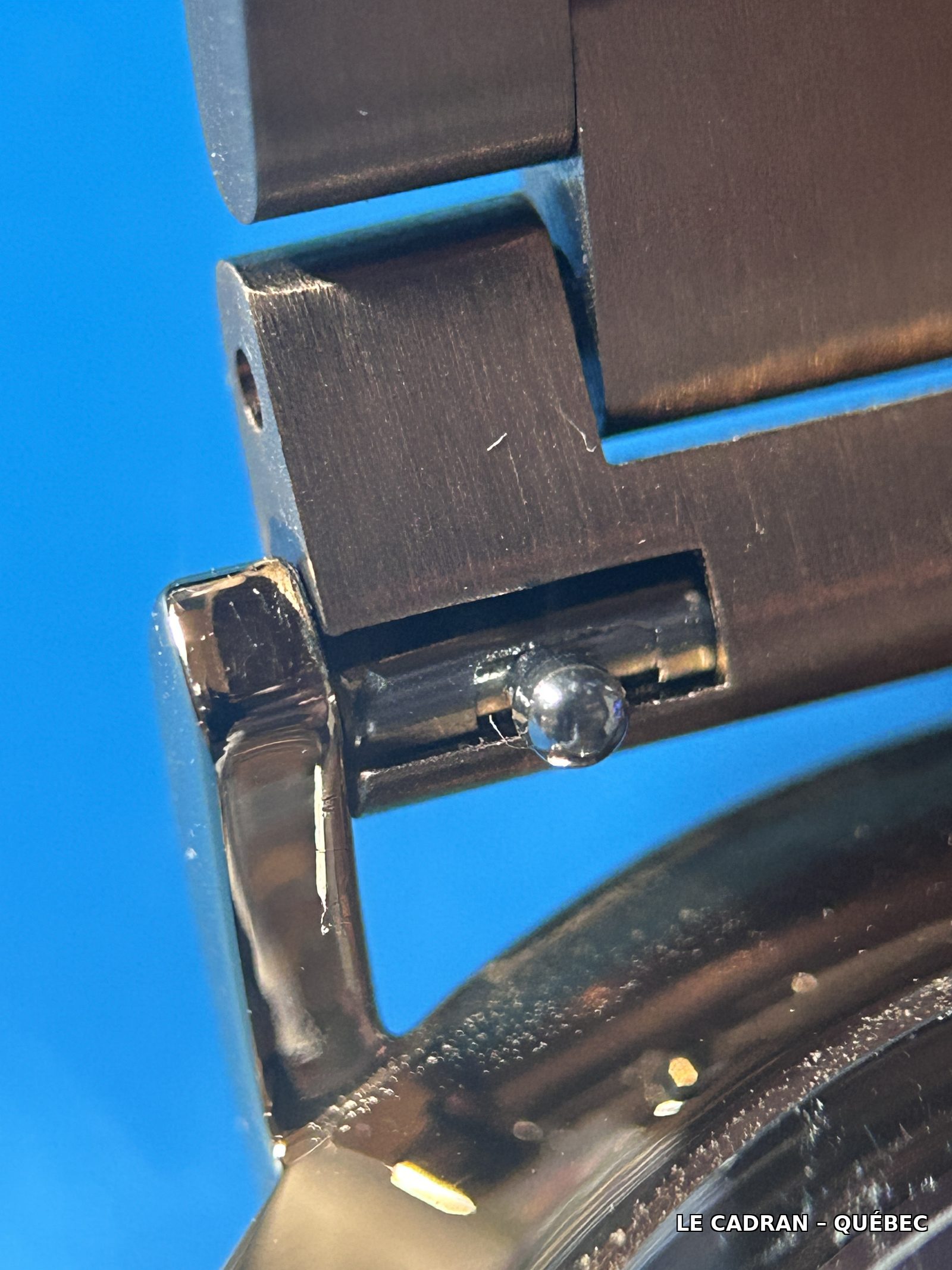 Levier de dégagement rapide visible sur une barrette à ressort, entre les cornes du boîtier